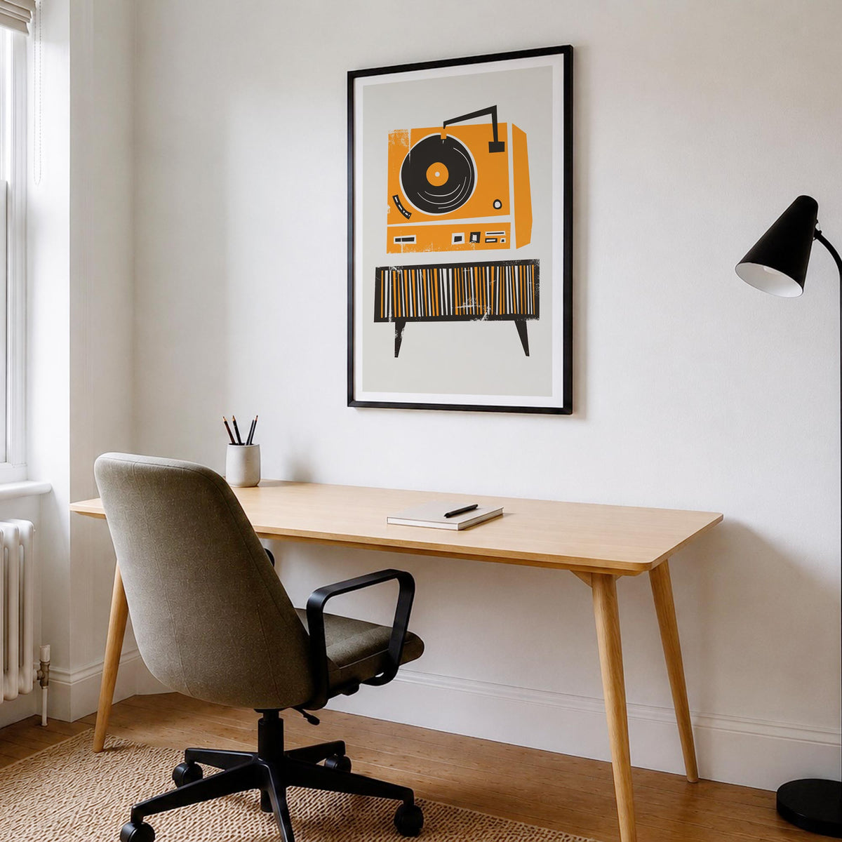a home office setup with a chair table lamp and a framed illustration of a vinyl record deck by fox & velvet