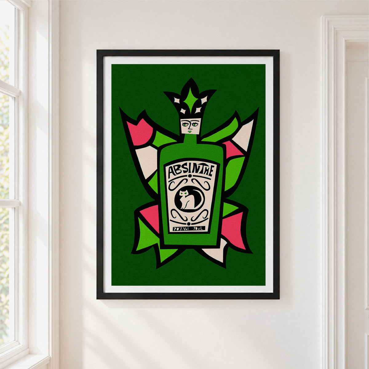 A framed art print featuring a stylized green Absinthe bottle with a jester hat, set against a dark green background with pink, white, and green abstract shapes. The print is displayed on a white wall next to a window.