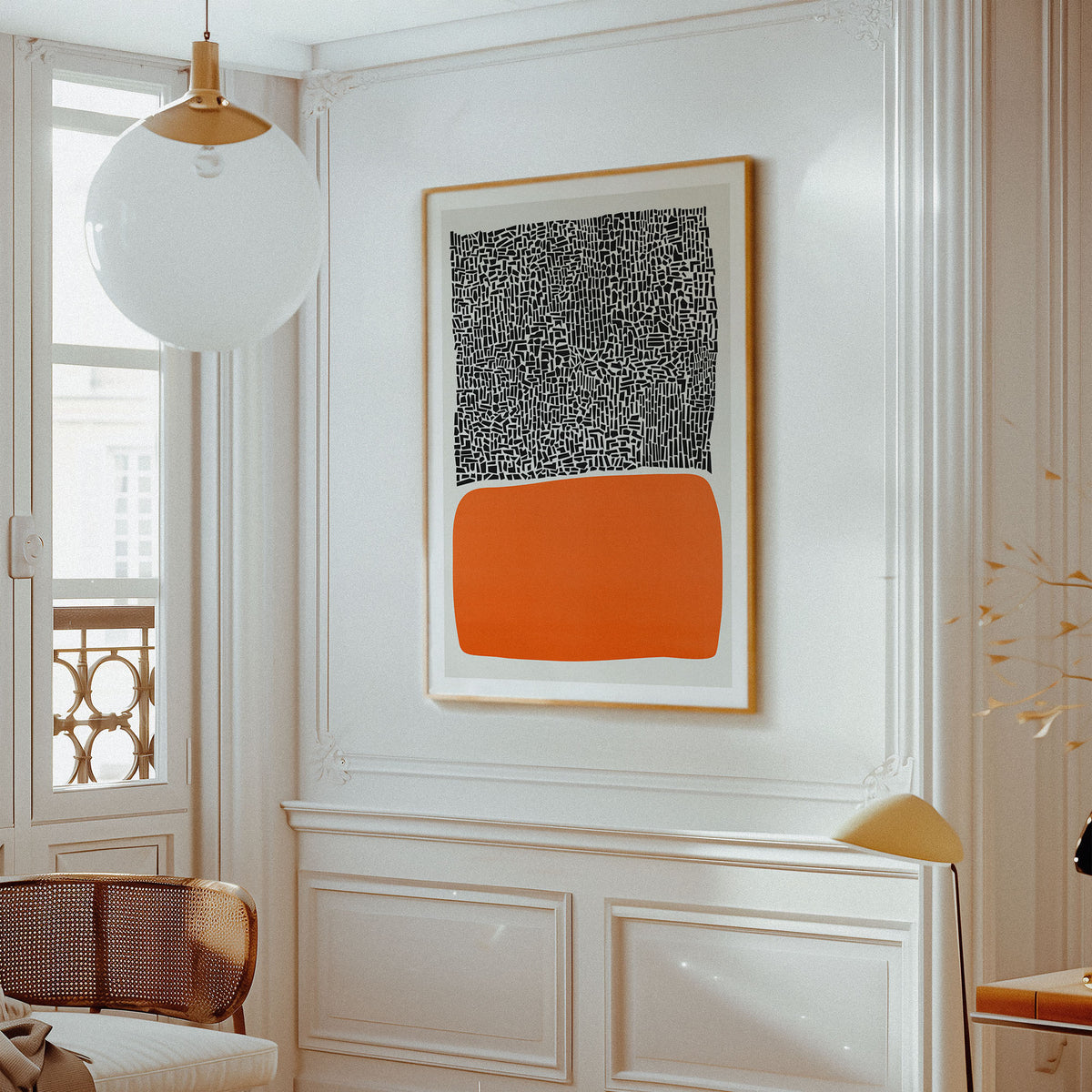 A framed abstract art print 'City Sunset' featuring a black and white patterned top half and a solid orange bottom half, hanging on a white paneled wall in a bright, modern room.