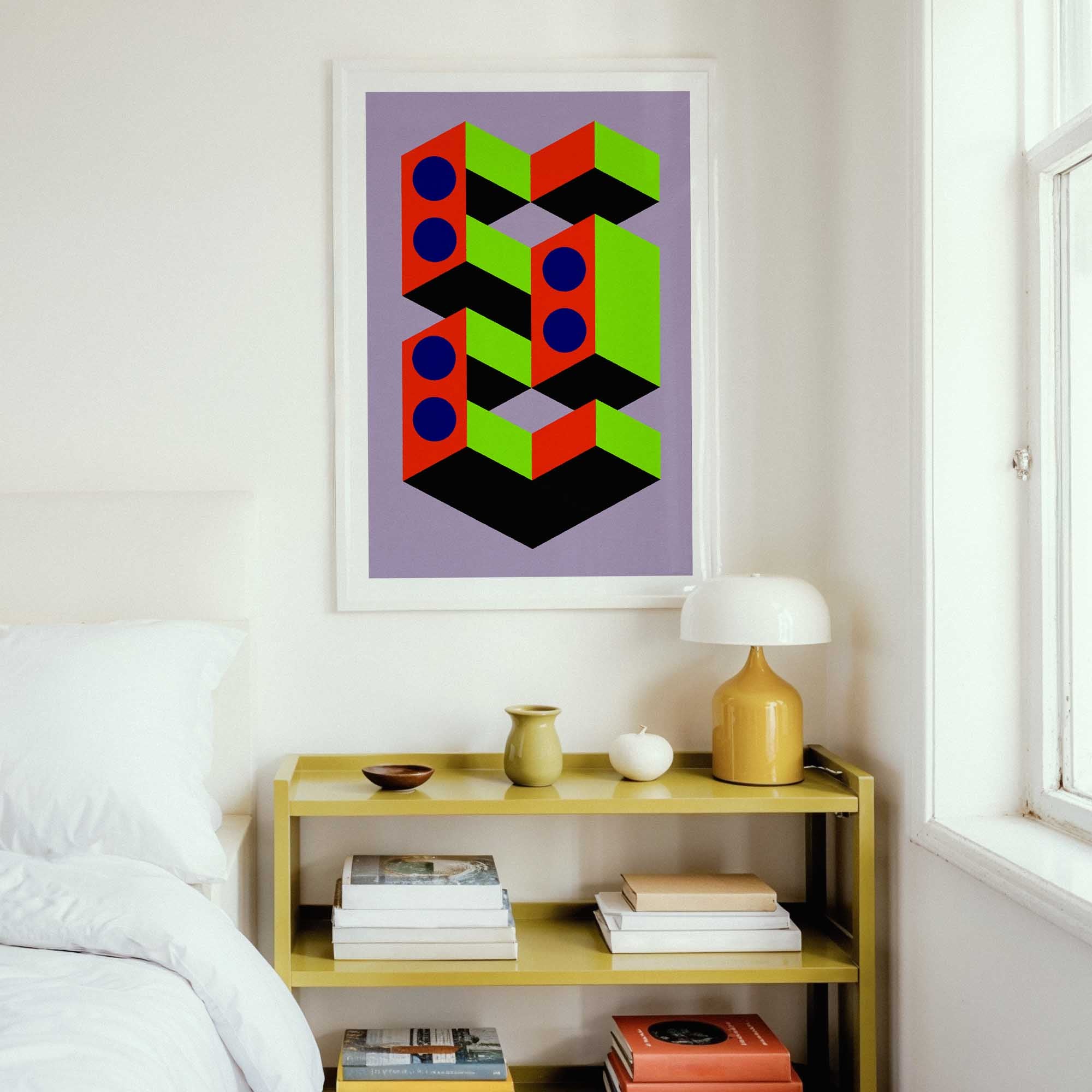 Geometric abstract art print on a wall above a shelf with books and decor.