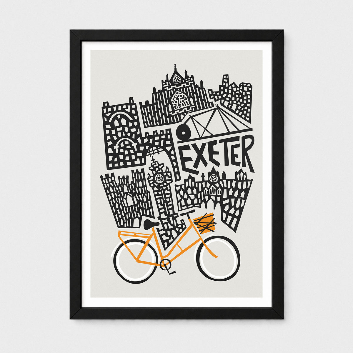 A framed art print featuring a black and white hand-drawn illustration of Exeter landmarks with an orange bicycle at the bottom, displayed on a light gray background.