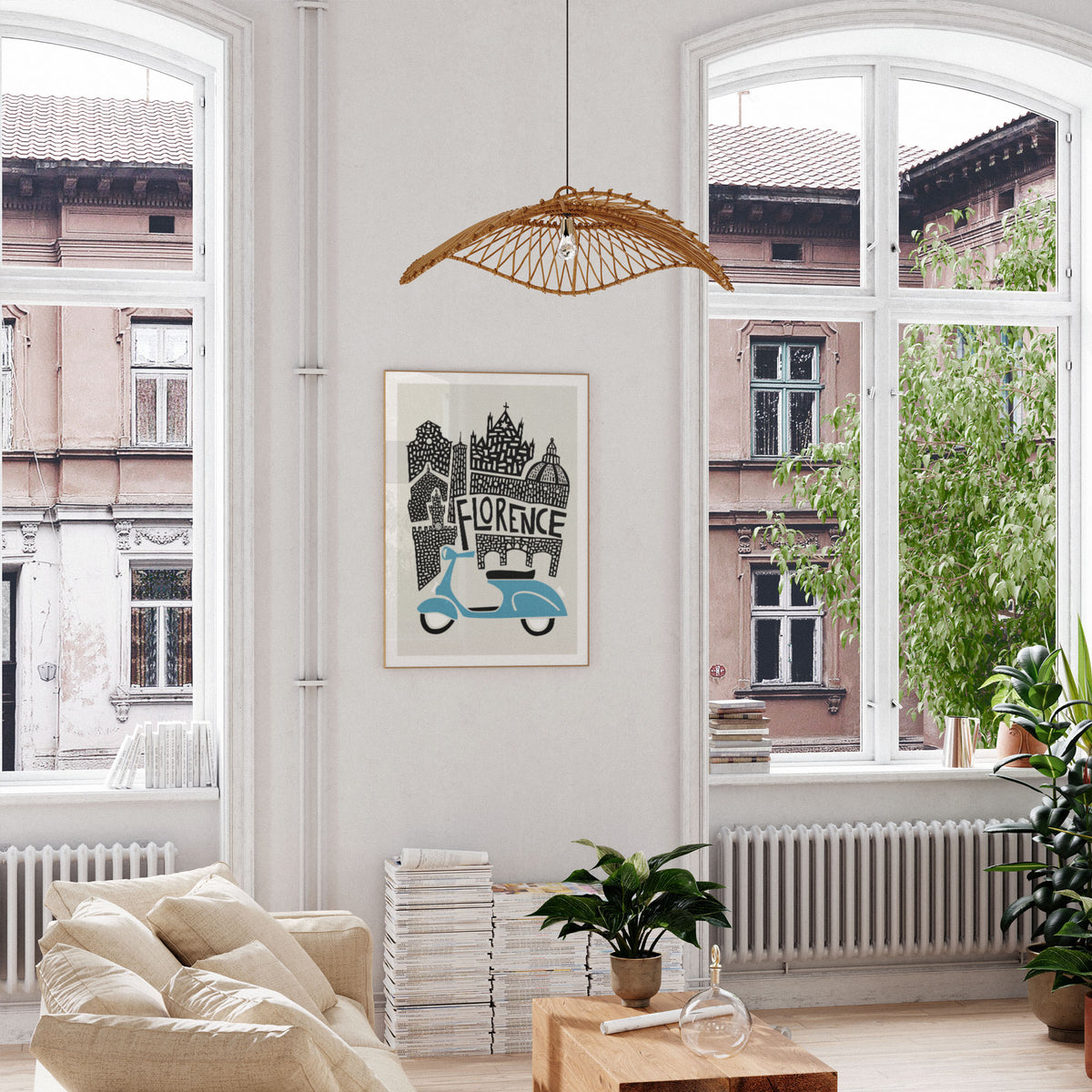 A framed art print featuring a light blue scooter and the word 'FLORENCE' in a black-and-white architectural illustration, hanging on a white wall in a bright, modern living room with large windows and plants.