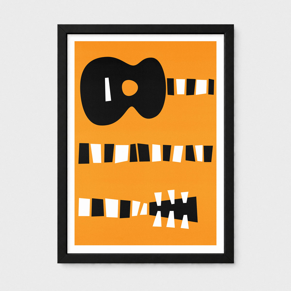 Framed minimalist art print featuring a stylized black guitar silhouette and geometric string details on a bright orange background, set in a black frame with a white mat against a light gray wall.