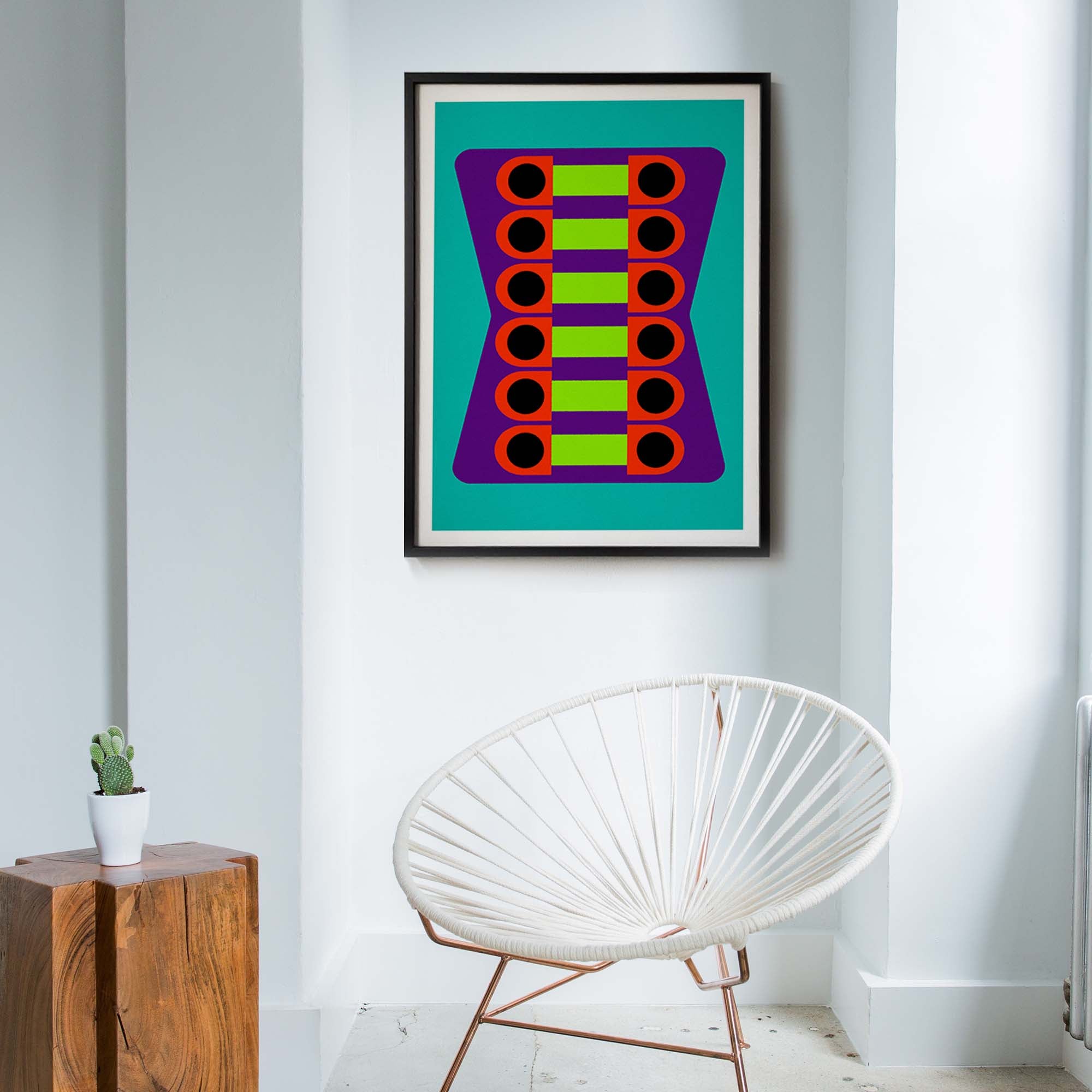 Framed abstract art piece on a wall with a modern chair and plant in the foreground.