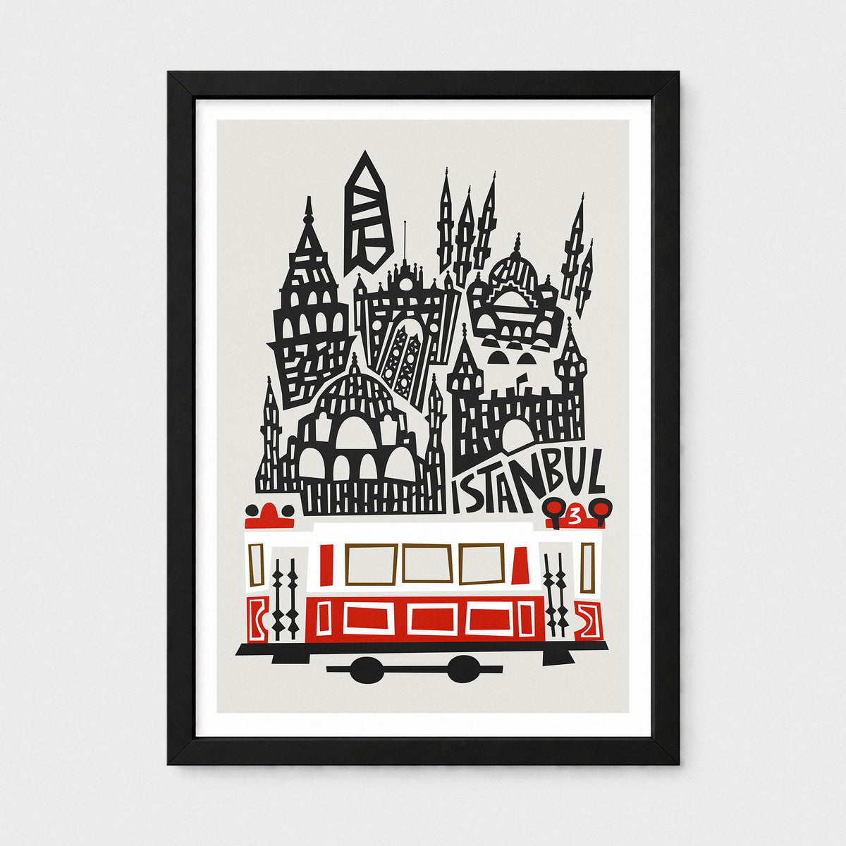 Framed Istanbul art print featuring a stylized black and white cityscape with a red and cream tram, shown in a black frame against a light gray background.