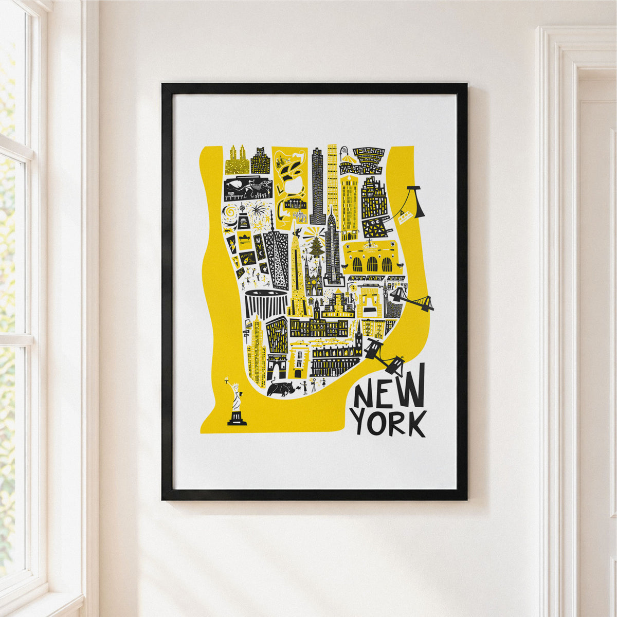 Manhattan map illustration in black frame on a cream wall next to a window.