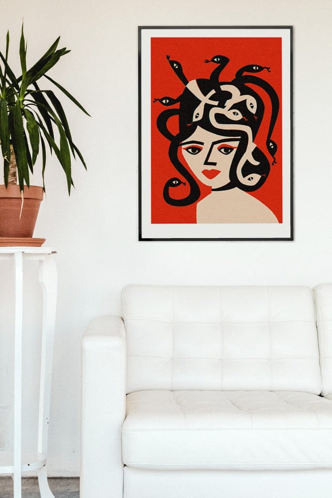 Medusa portrait illustration in black frame above a trendy white sofa with green plant