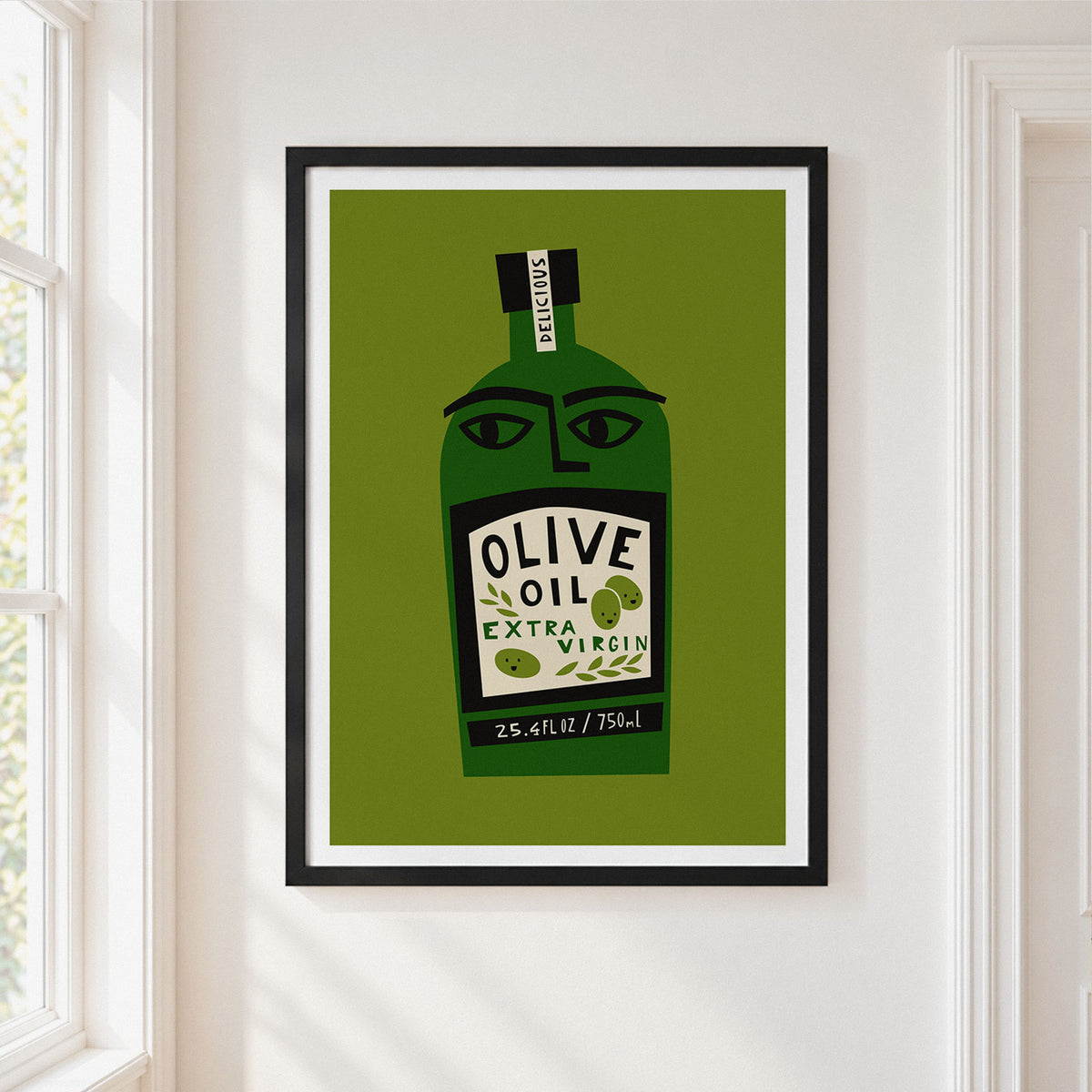 Framed wall art featuring a stylized olive oil bottle illustration in green, black, and cream, hung on a white wall beside a window.