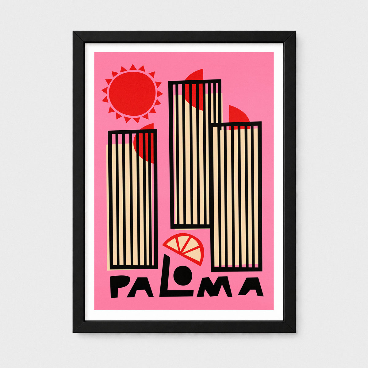 A framed art print featuring a retro-style illustration of the city of Palma, with three striped skyscrapers, a red sun, and the word 'PALOMA' in bold black letters on a pink background, shown in a black frame against a light gray wall.