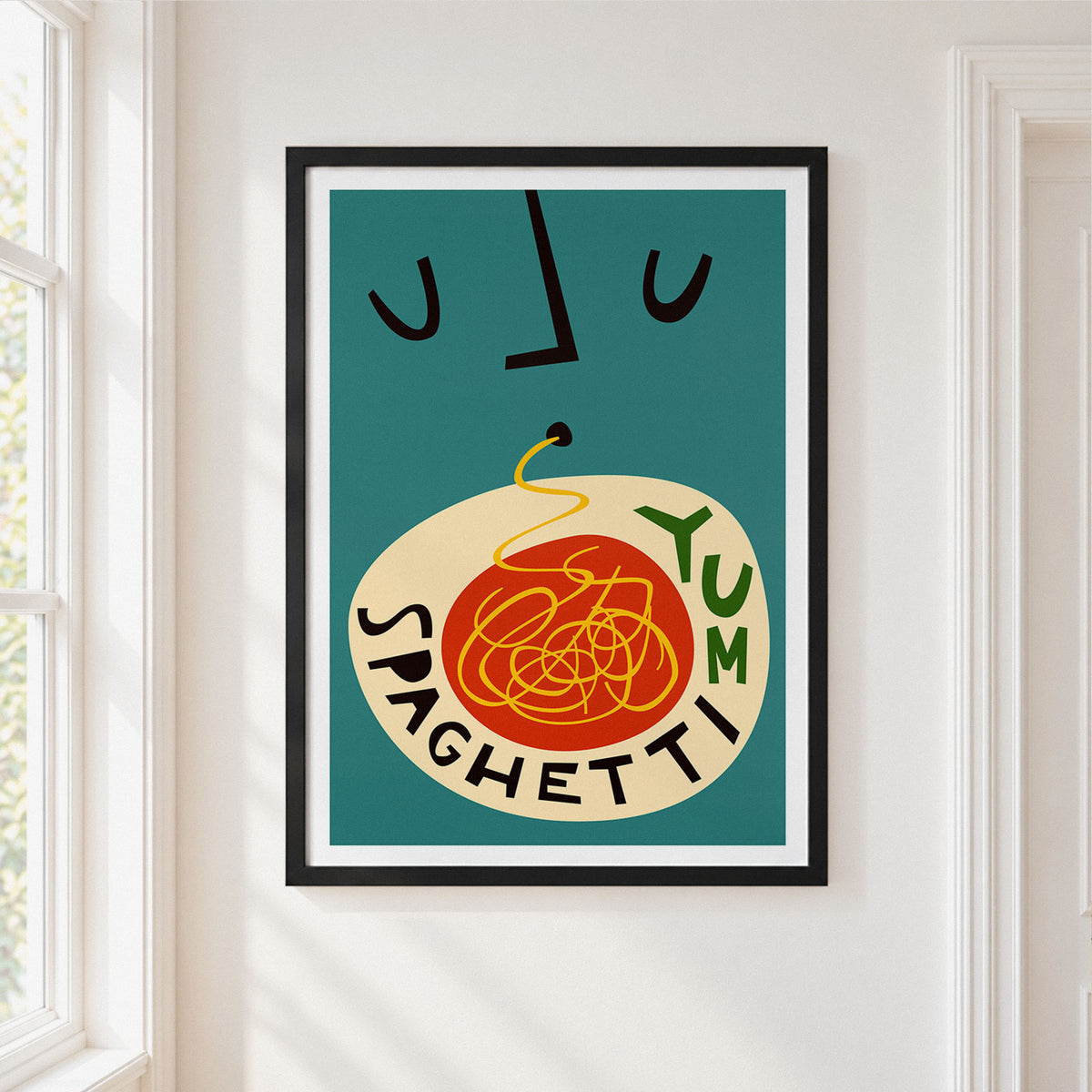 A framed art print featuring a retro-style illustration of spaghetti with the word 'SPAGHETTI' and 'YUM' integrated into the design, hanging on a white wall next to a window.