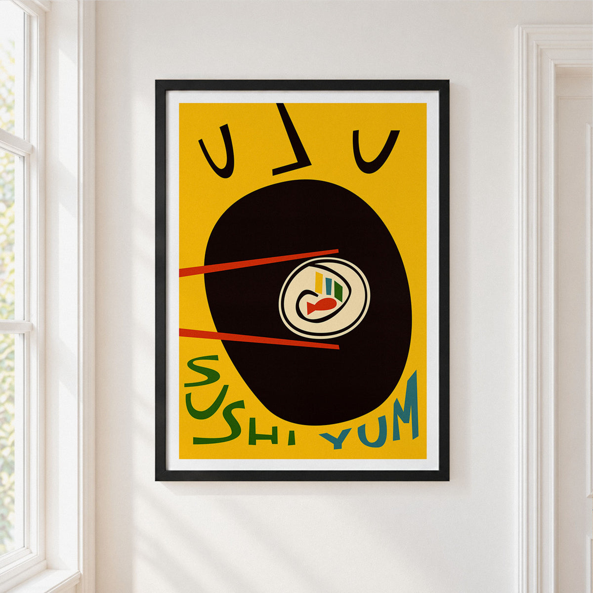 A framed minimalist art print featuring a black vinyl record with chopsticks and sushi, set against a mustard yellow background with the text 'SUSHI YUM'. The print is framed in black with a white mat, hanging on a white wall next to a window.