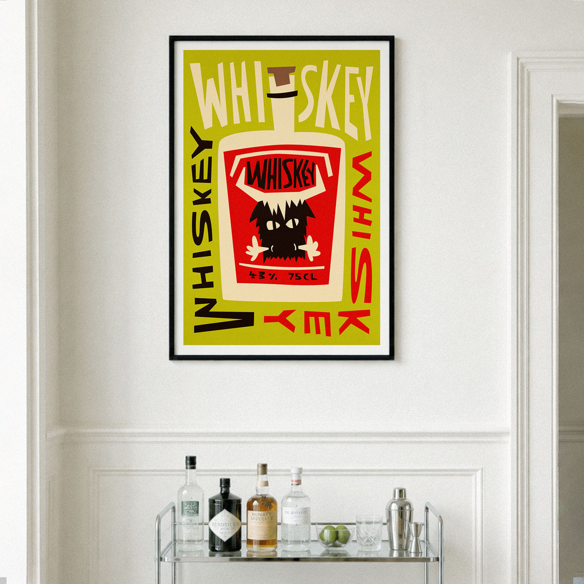 A framed art print featuring a stylized whiskey bottle illustration with the word 'Whiskey' repeated around it, hanging on a white wall above a glass bar cart with bottles and glasses.