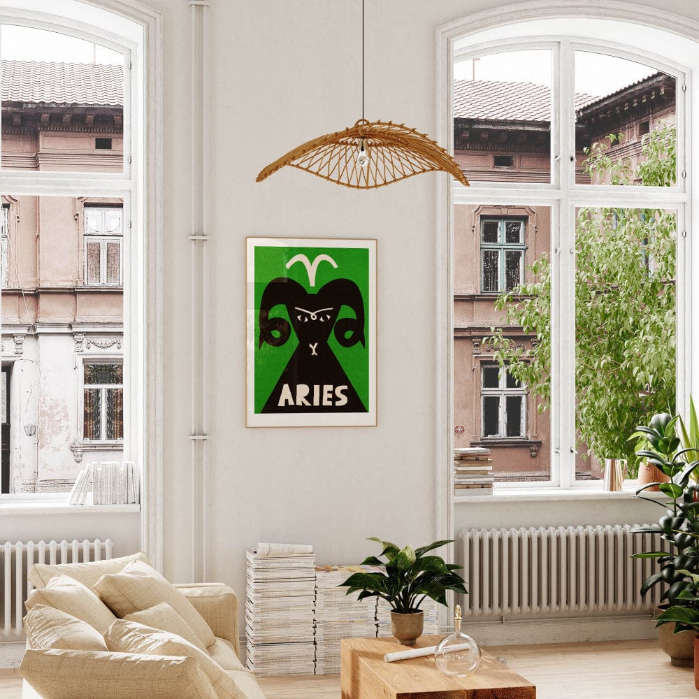 Aries poster framed above a cream-coloured sofa in a light-filled room with indoor plants and woven lighting.