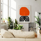 The Aurelia print hung above a beige sofa, where its high-contrast colours and retro form give the neutral space a playful and graphic focal point.
