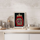 BBQ Sauce print framed on a stone-textured kitchen shelf styled with bar tools and glasses.