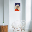 Blond graphic portrait framed in a white minimalist room with natural wood and wire-frame chair