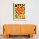 Fun fruit poster styled above a minimalist wooden sideboard.