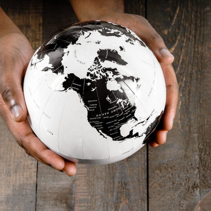 a small globe being held by a pair of hands.
