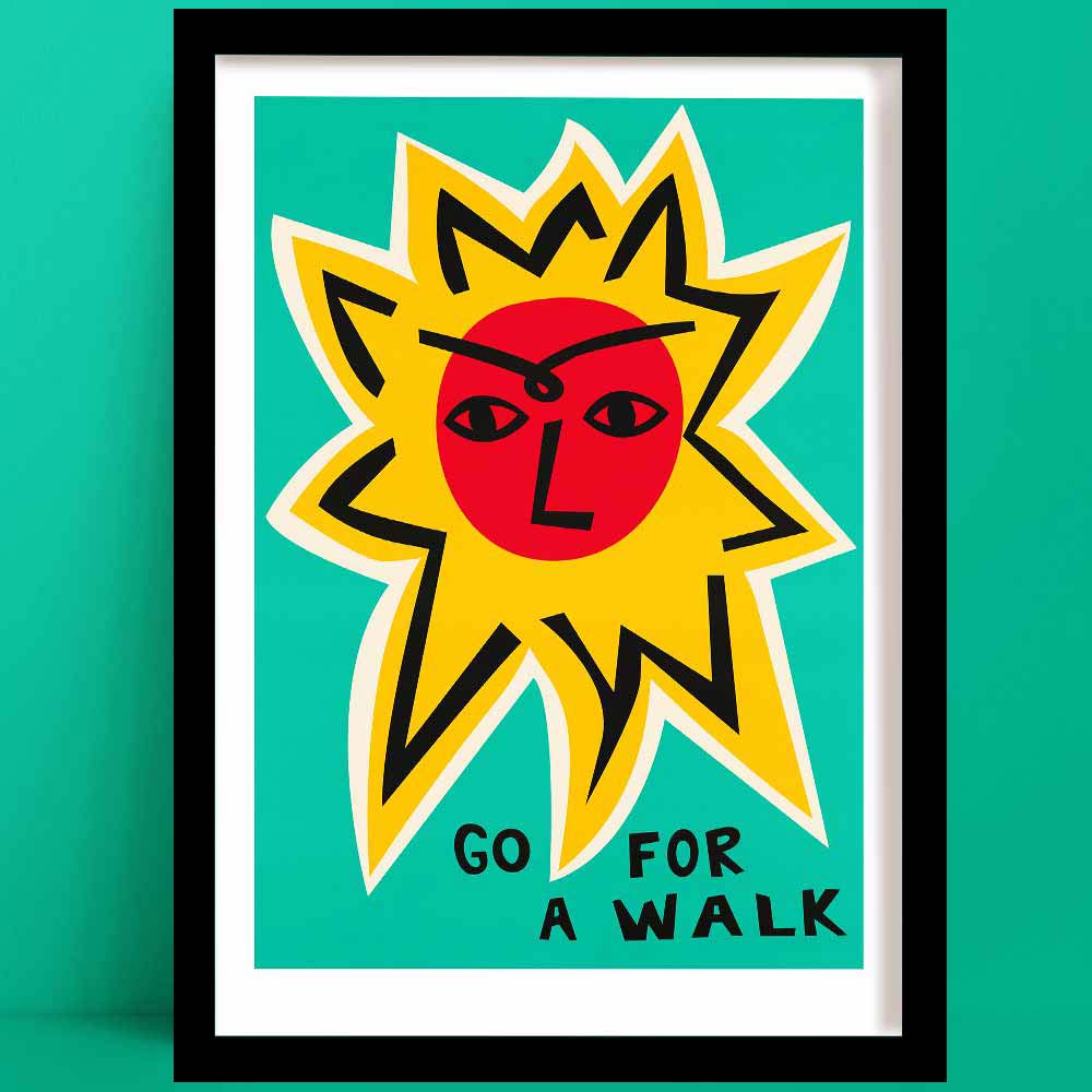 Go For a Walk Sun inspirational print, featuring a bold red sun face with yellow rays and hand-lettered text, framed on green wall.