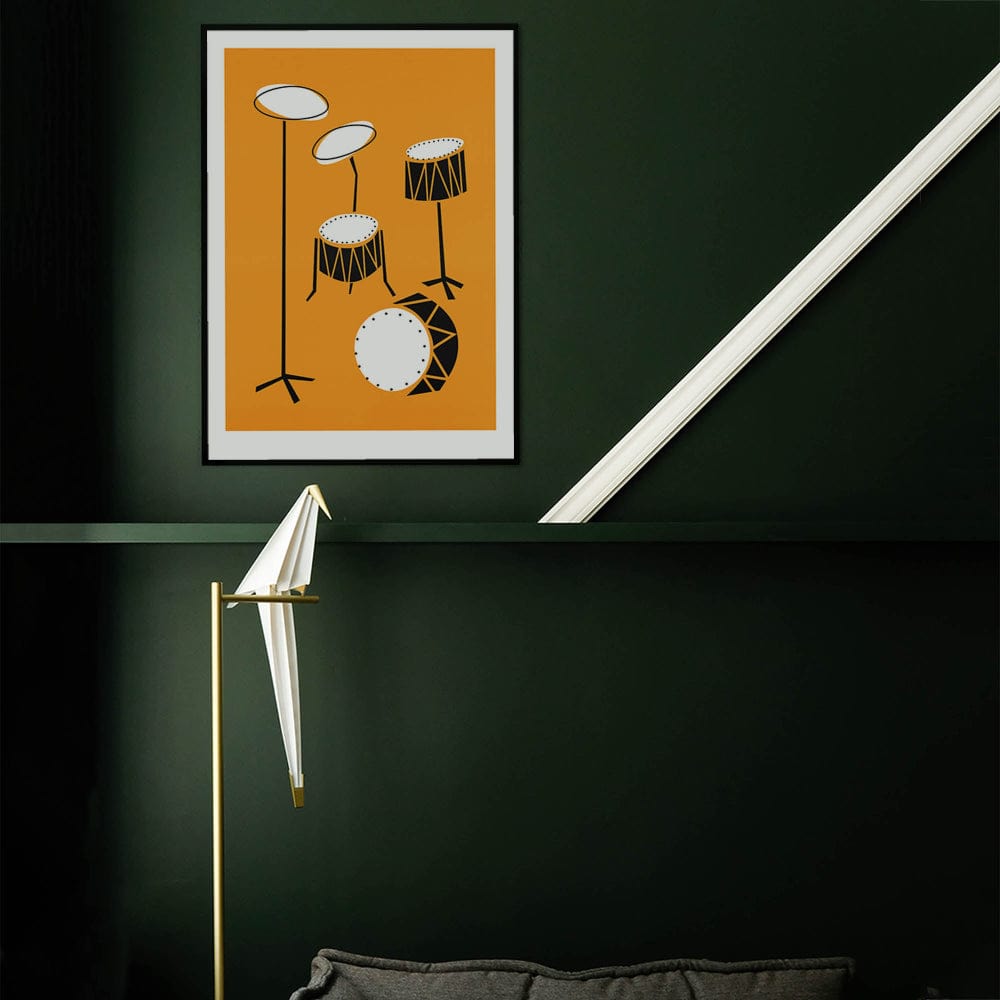 Drum kit art print hanging on a dark green wall with a white diagonal ceiling beam and spotlight below