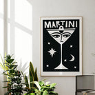 Martini print hung in a light-filled room; its bold monochrome palette contrasts beautifully with the serene white walls and natural light.