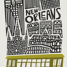 A close-up showcasing the stylised architecture and ornate lettering of “New Orleans,” sitting above the city’s iconic vintage streetcar in olive green.