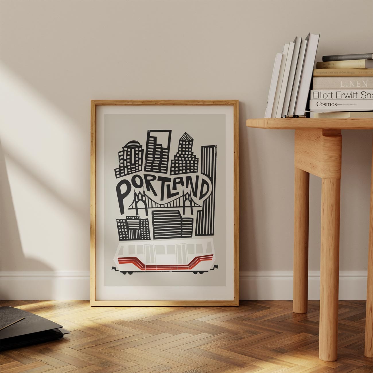 The Portland art print propped on a floor against a white wall, with sunlight casting long shadows across the classic architectural lines.