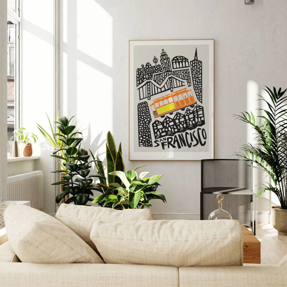 The San Francisco city print framed and displayed in a light-filled lounge, with soft neutral décor and leafy greens adding warmth to the urban energy of the artwork.
