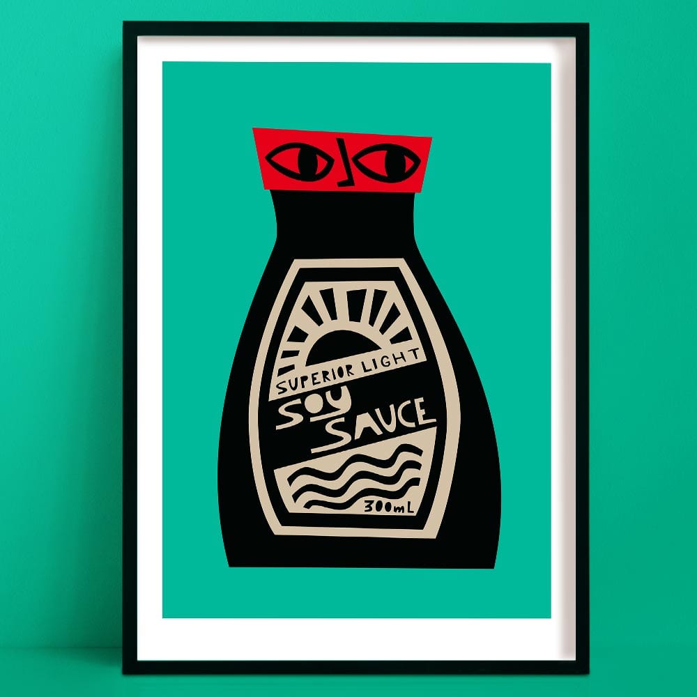Soy Sauce print featuring a black bottle with red lid, stylised label and graphic face, framed on green wall.