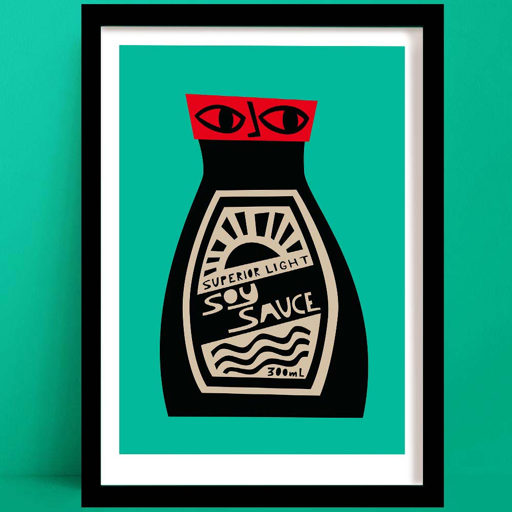 Soy Sauce print featuring a black bottle with red lid, stylised label and graphic face, framed on green wall.