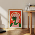 Sun halo portrait print leaning against wall next to wooden desk and stack of books