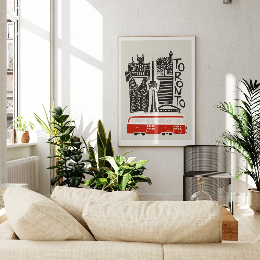 The Toronto print displayed above a beige sofa in a cosy corner, balancing crisp urban lines with the warmth of a handmade, screenprint-inspired texture.