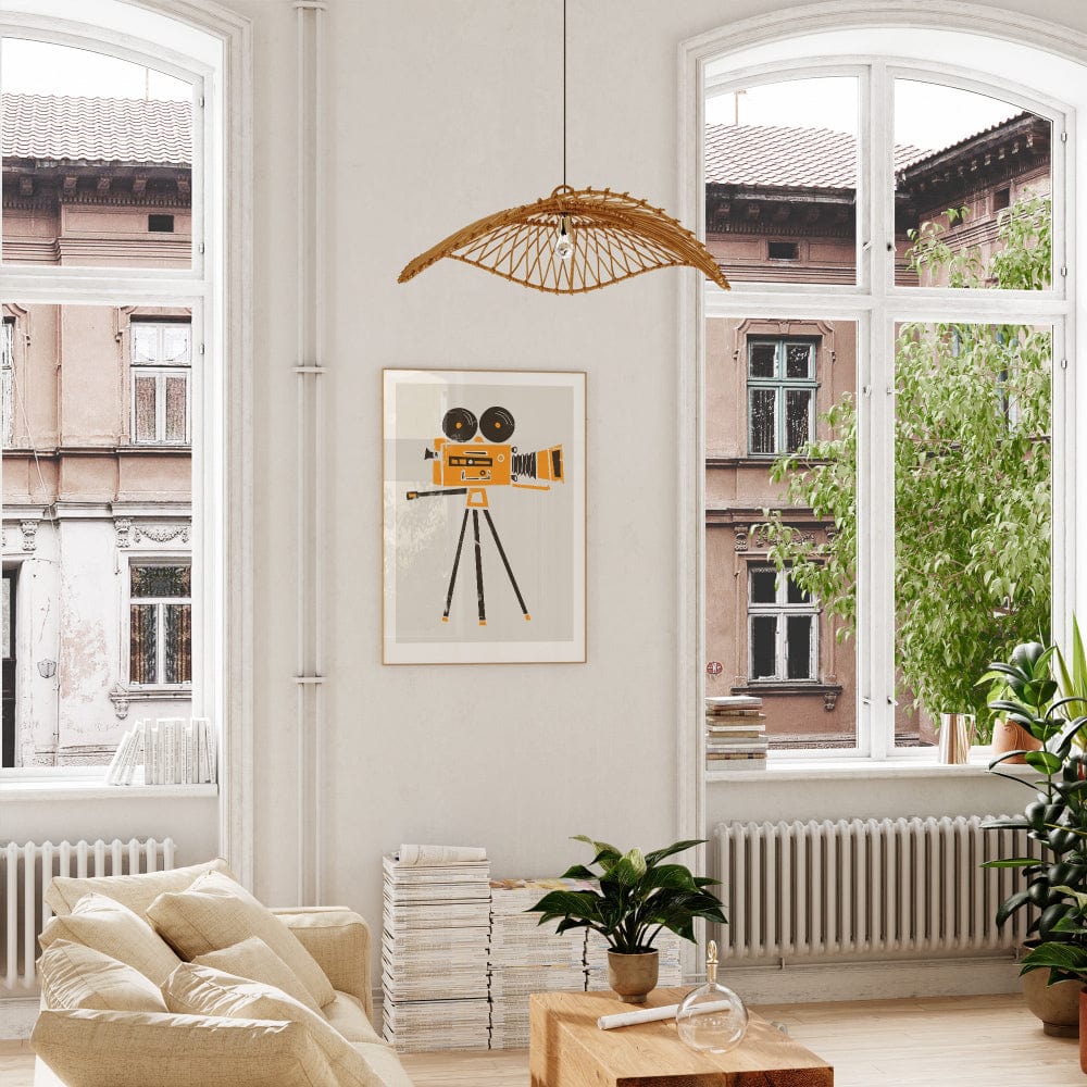 Framed cine film camera art print displayed in a bright, white room with soft natural light, bringing energy and creativity to the wall with its bold graphic style.