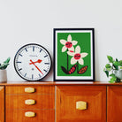 Don’t Despair print framed above a vintage wooden cabinet, styled with plant and clock.
