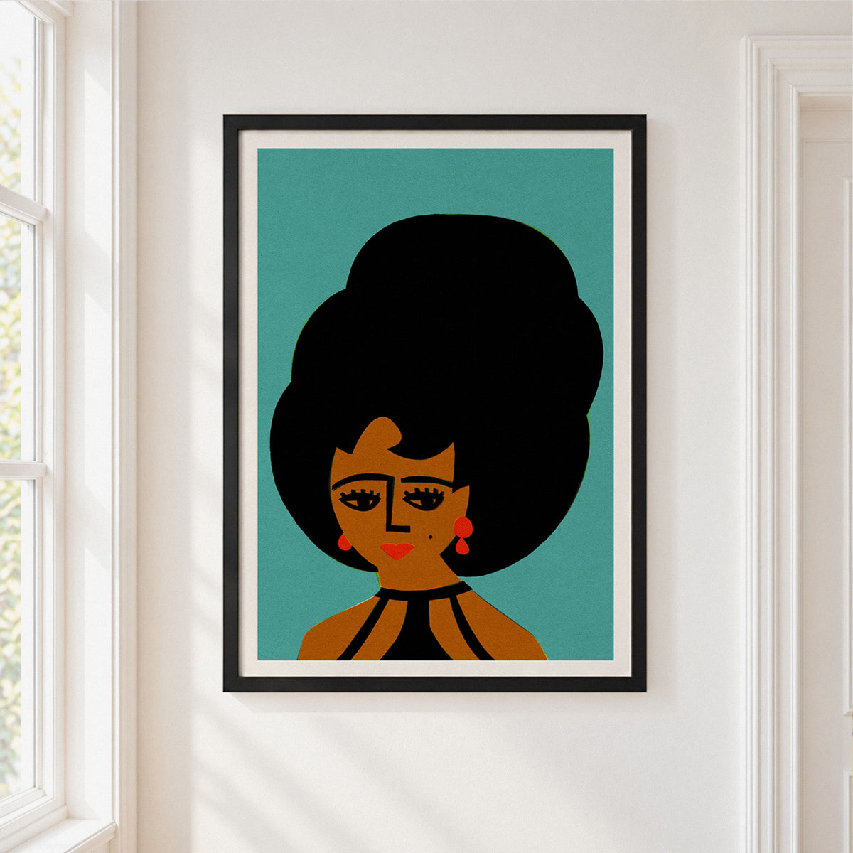A framed art print featuring a retro-style illustration of a woman with a large black afro hairstyle, set against a teal background, hanging on a white wall next to a window.