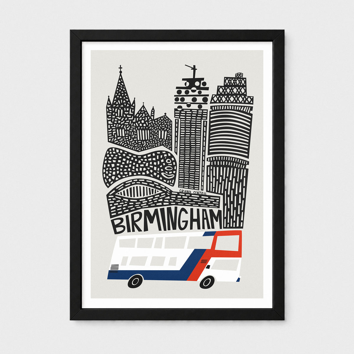 A framed art print featuring a stylized black and white illustration of Birmingham landmarks and a red, white, and blue double-decker bus on a light gray background, shown against a neutral light gray wall.