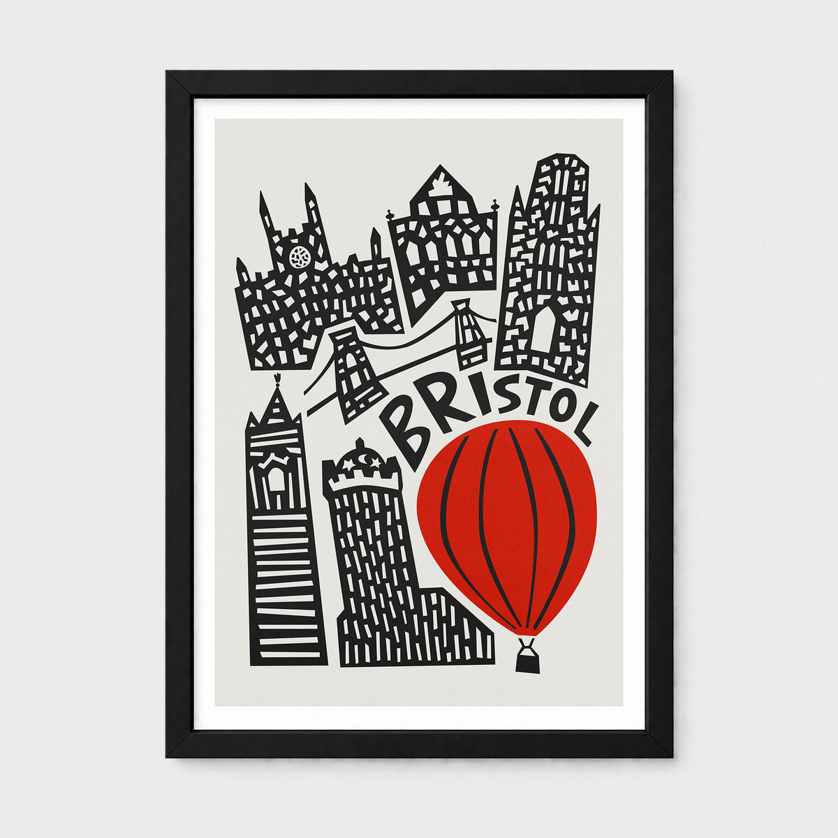 Framed art print featuring a stylized black line illustration of Bristol landmarks, including a red hot air balloon and the word 'BRISTOL' in black script, on a light gray background.