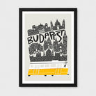 A framed Budapest travel art print featuring a black and white skyline illustration with the word 'BUDAPEST' and a yellow bus at the bottom, shown against a light gray background.