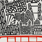 A close-up of a graphic print featuring stylized black cityscape silhouettes on a light gray background, with a bold red horizontal band across the bottom.