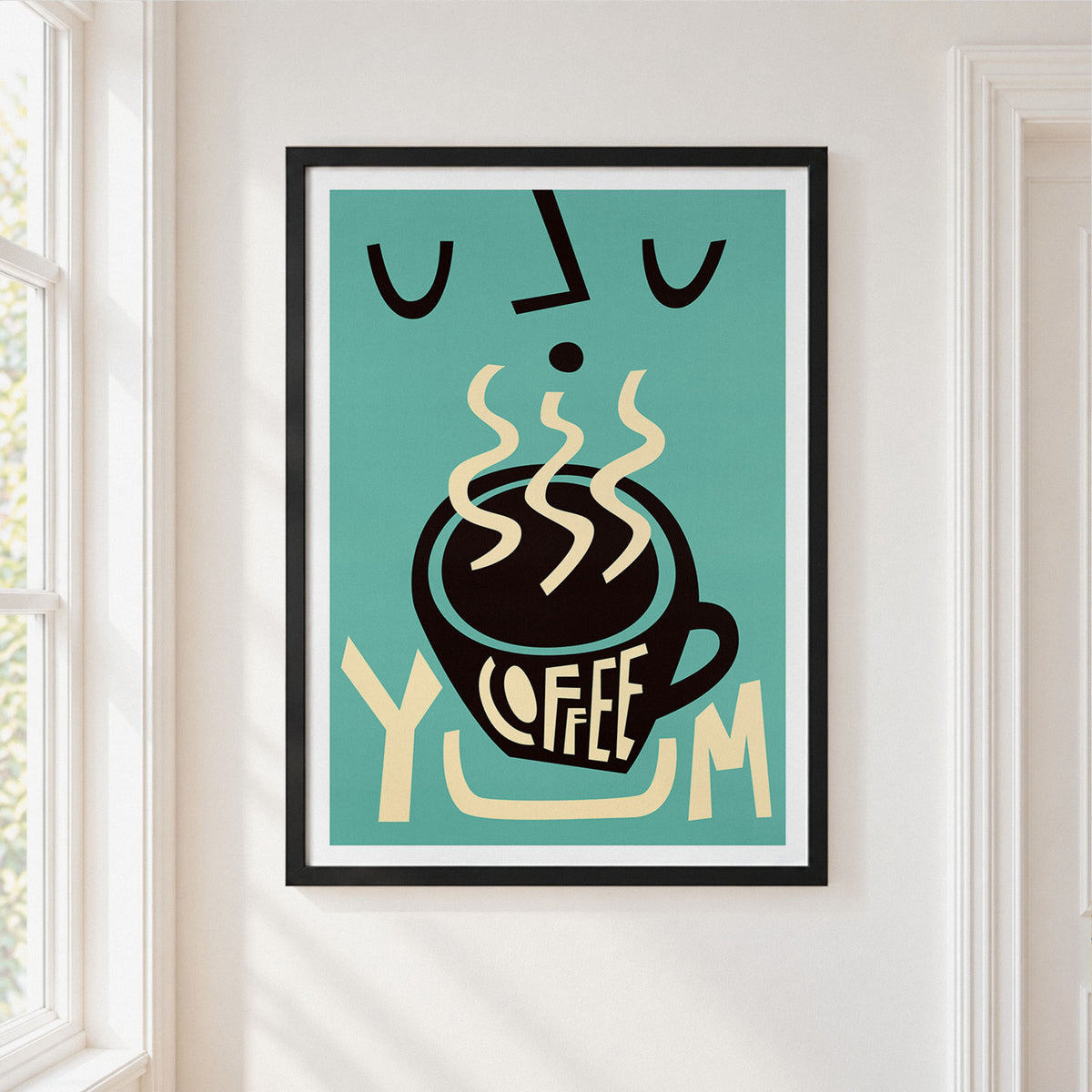 A framed art print featuring a retro-style coffee cup illustration with the word 'COFFEE' and steam, hung on a white wall next to a window.