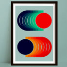 Framed abstract geometric wall art print featuring colorful isometric shapes on a light blue background, shown hanging against a matching light blue wall.
