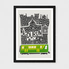 A framed art print featuring a stylized black and white cityscape with the word 'DUBLIN' and a green and yellow train at the bottom, shown against a light gray background.