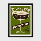 A framed art print featuring a retro-style illustration of an espresso martini glass on an olive green background, with the words 'ESPRESSO' and 'MARTINI' in cream and dark brown. The print is displayed in a black frame with a white mat against a light gray wall.