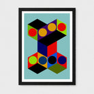 Framed abstract geometric wall art featuring overlapping black cubes with colorful circular and polygonal facets on a light blue background, shown in a black frame with white mat against a light gray wall.