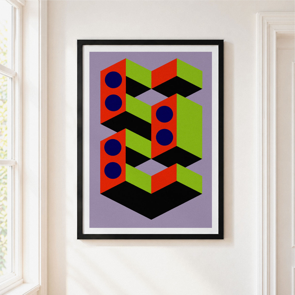 Framed abstract geometric wall art hanging on a white wall next to a window. The print features bold, colorful block shapes in red, lime green, black, and navy blue on a lavender background, enclosed in a black frame with a white mat.