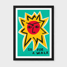 Framed art print featuring a stylized yellow sun with a red face on a teal background, with the typography lettering 'GO FOR A WALK' in black at the bottom. The print is mounted with a white mat and enclosed in a black frame, shown against a light gray wall.