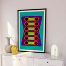 Framed abstract art piece with geometric design on a white wall
