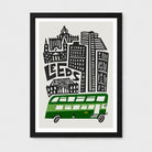 Framed art print featuring a stylized black and white cityscape with the word 'LEEDS' and a green double-decker bus on a light gray background, shown in a black frame against a light gray wall.