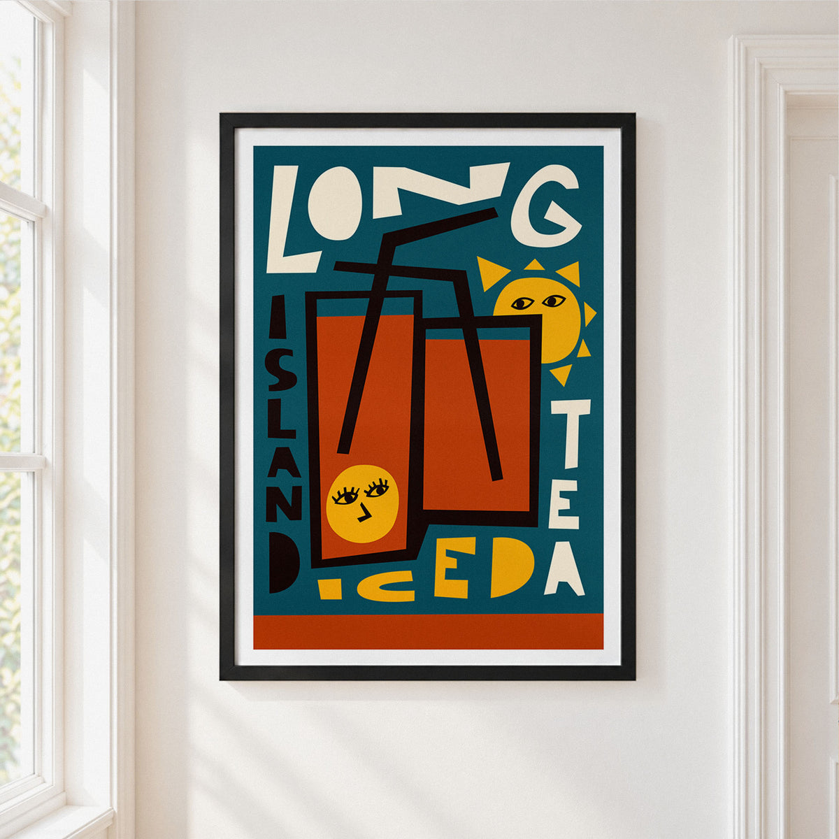A framed art print featuring a retro-style illustration of two glasses of iced tea with straws, a yellow sun, and bold text reading 'LONG ISLAND ICED TEA' on a teal background, hung on a white wall next to a window.