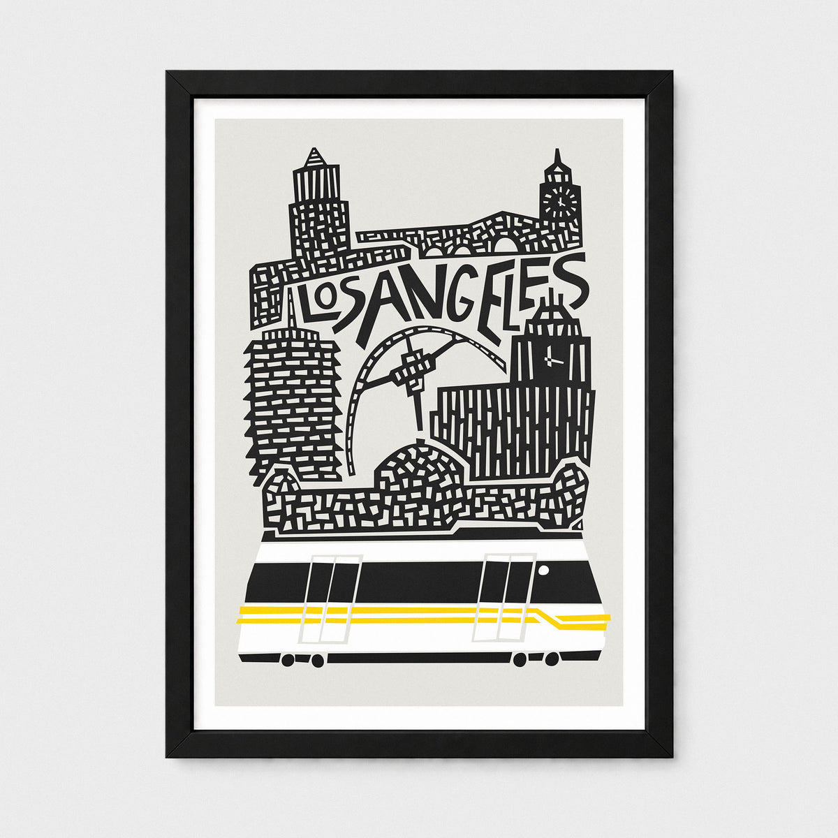 A framed art print featuring a stylized black and white illustration of the Los Angeles skyline with a yellow and black streetcar, shown against a light gray background.